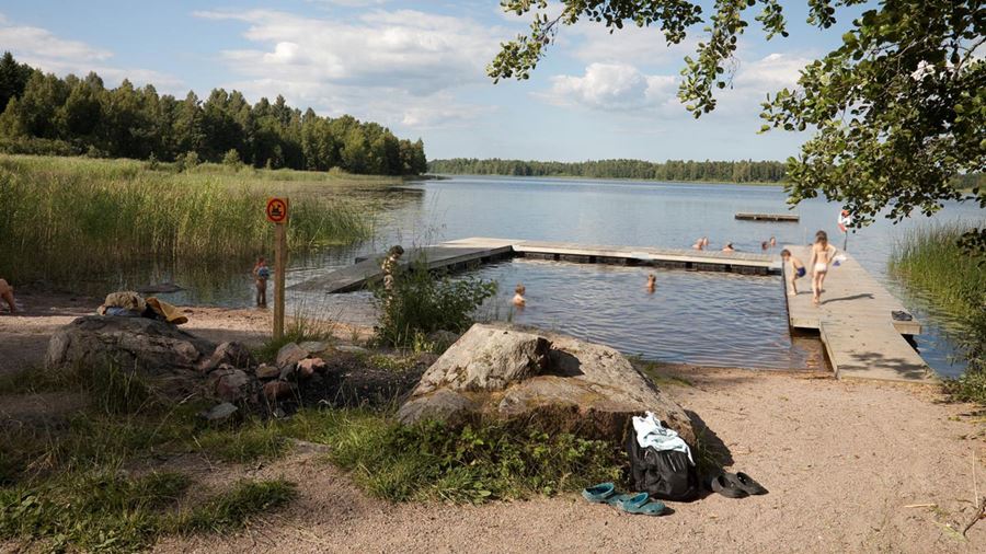Ett tiotal personer badar vid bryggan i Måviksbadet.