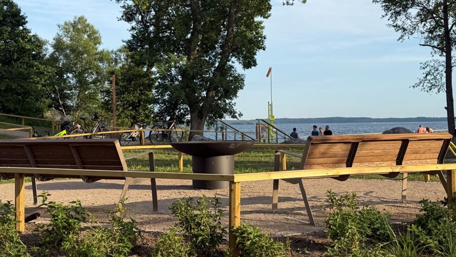 Grillplats med träbänkar och en fast grill i mitten
