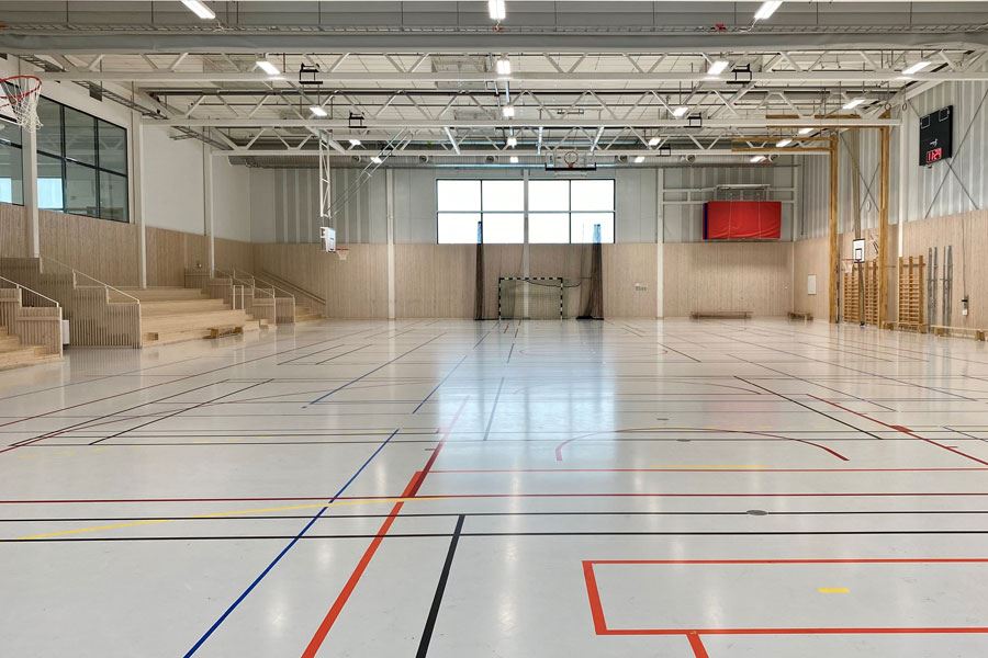 Interiörbild från Tiundaskolans idrottshall. Bilden visar gymnastiksalen med sidoläktare längs ena långsidan.