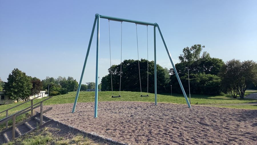 En hög gungställning med två gungor i parken.