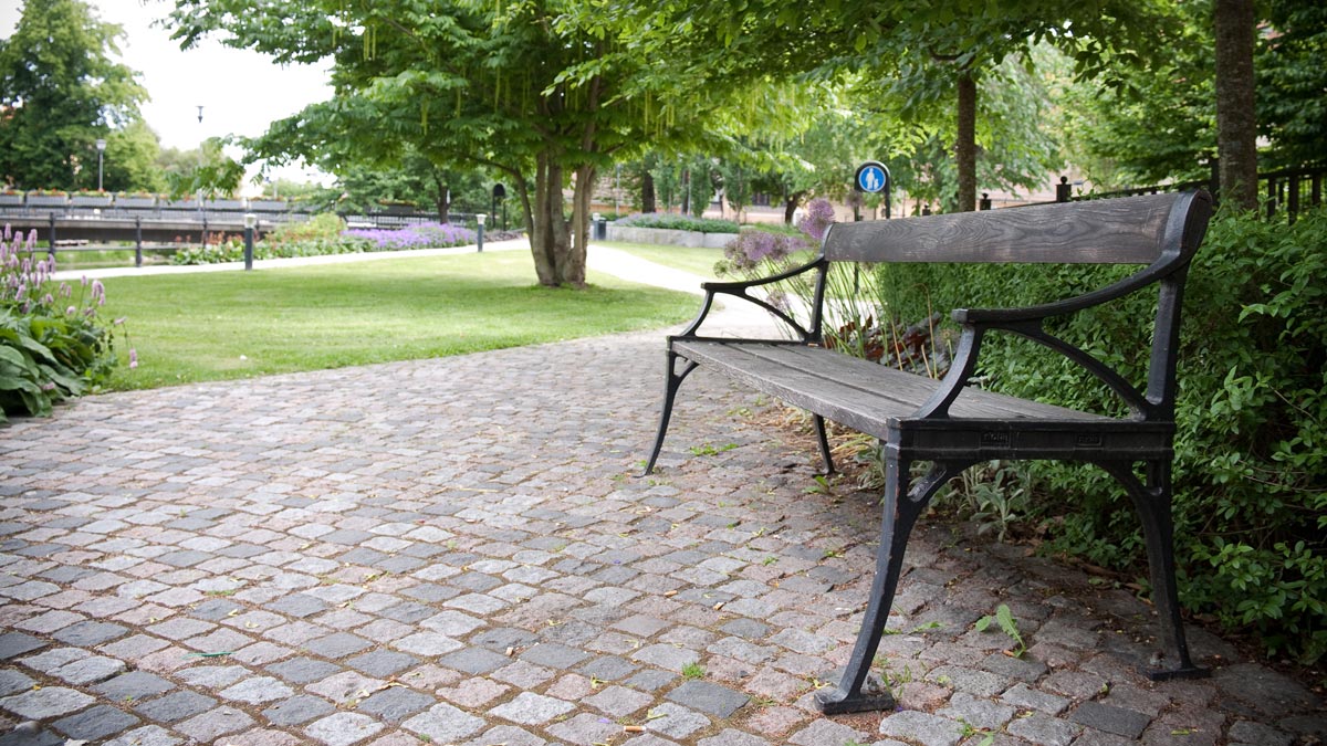 En parkbänk, gångväg och gräsytor i Artediparken.
