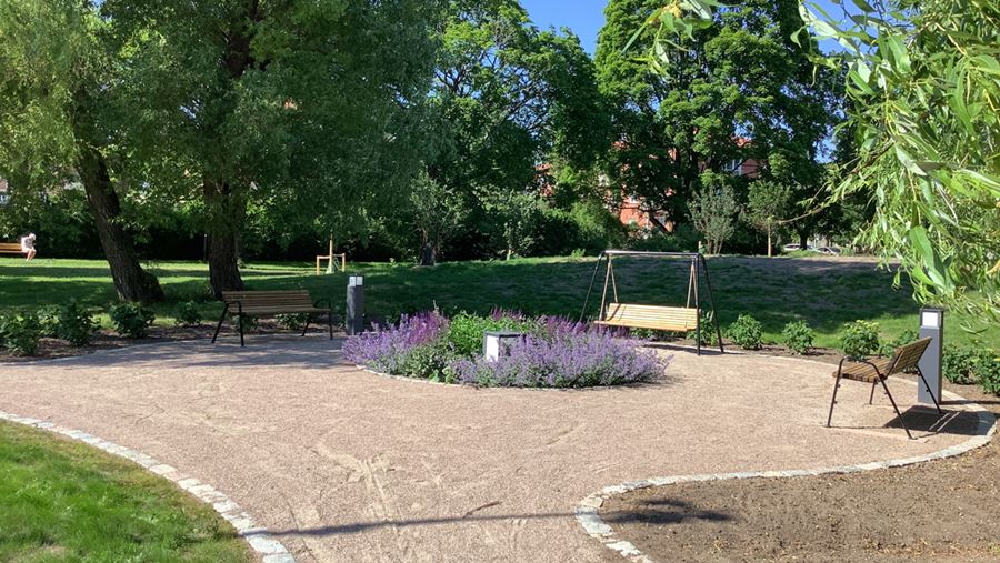 Grusgång med planeringar och sittplatser.