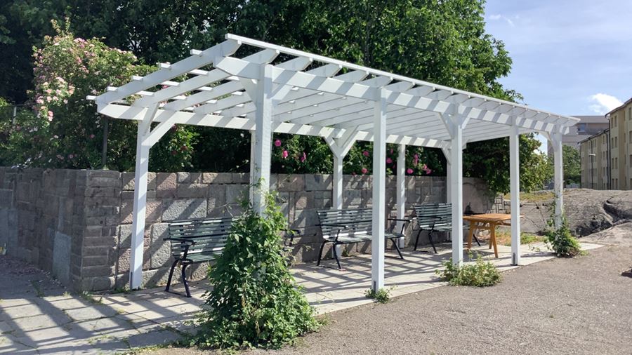 Pergola med sittbänkar under.