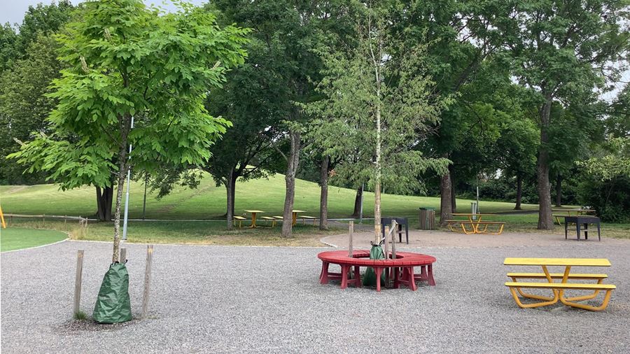 Sittbänkar och bord i parken.
