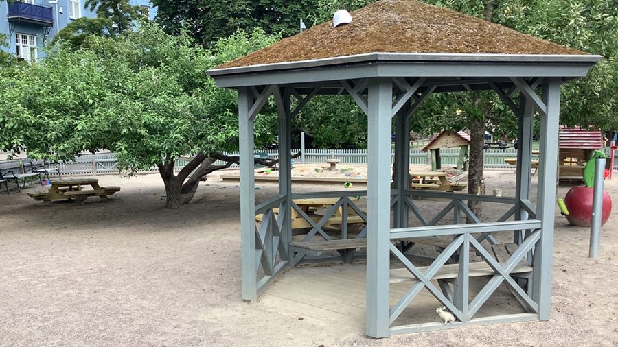 Lusthus vid lekplatsen i Vasaparken. I lusthuset finns sittplatser.