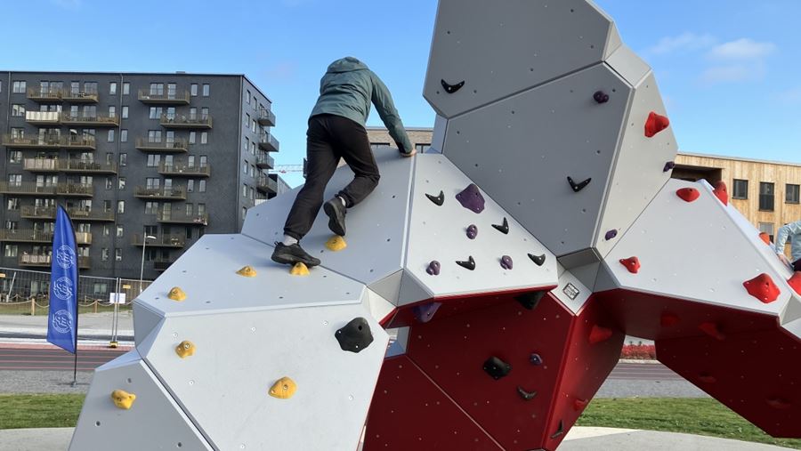 Ett barn klättrar på en slags klättervägg.