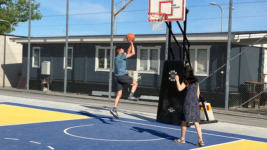 Två personer spelar basket ute