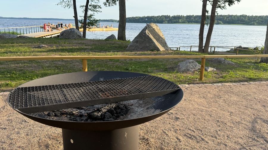 Närbild på en rund, fast grill på en grillplats