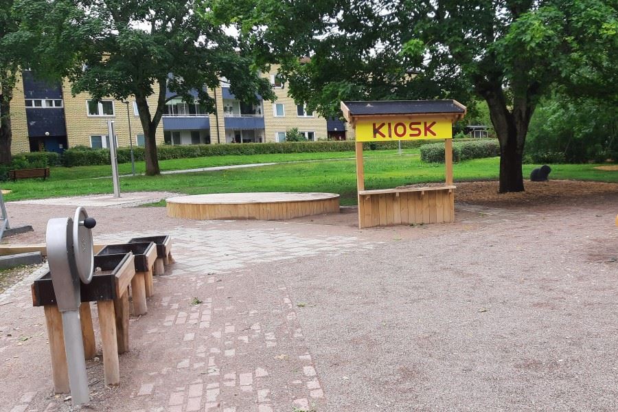 Park med vattenlek och leksakskiosk.
