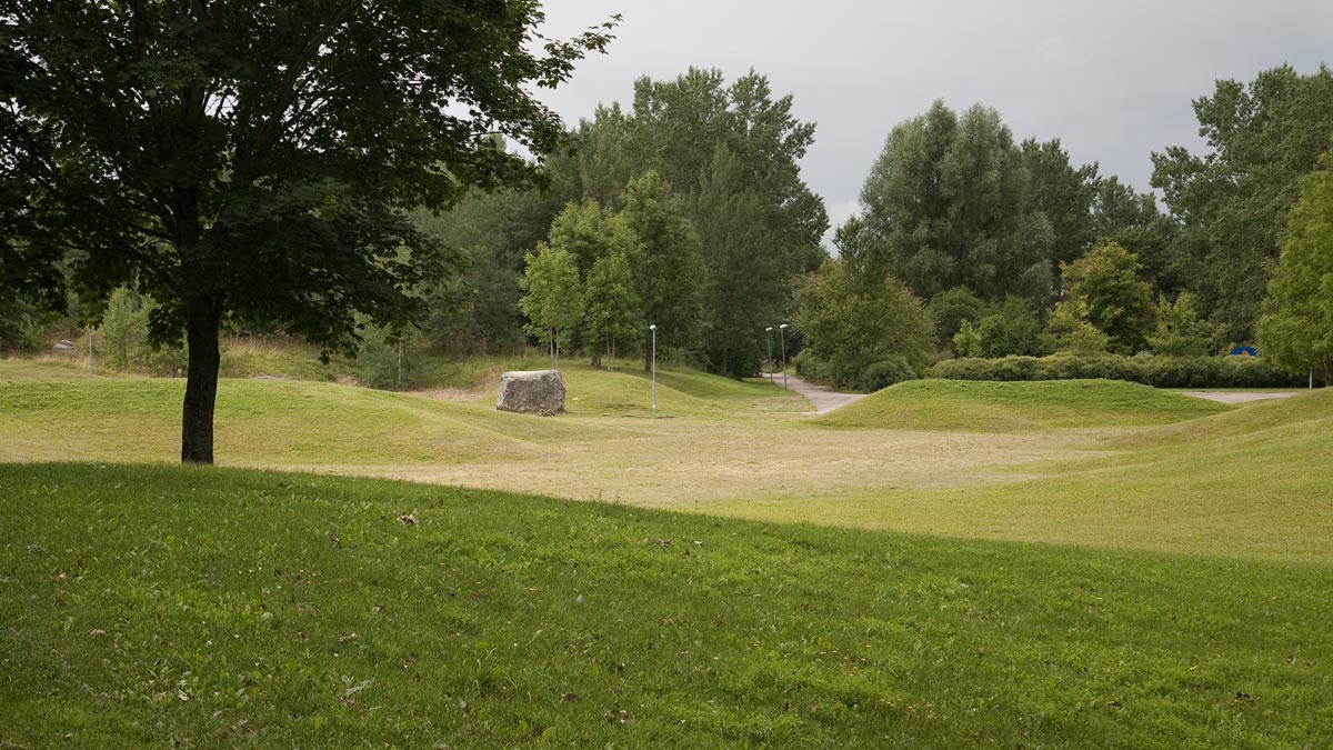 Stora gräsytor, träd och en gång- och cykelbana i Gränbyparken.