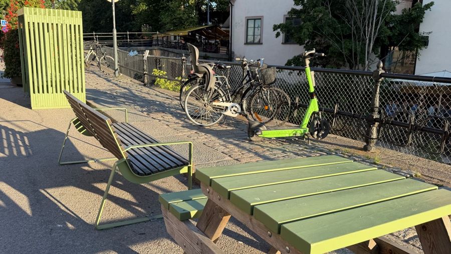 Bänkar, bord och cyklar som står parkerade längs med åräcket