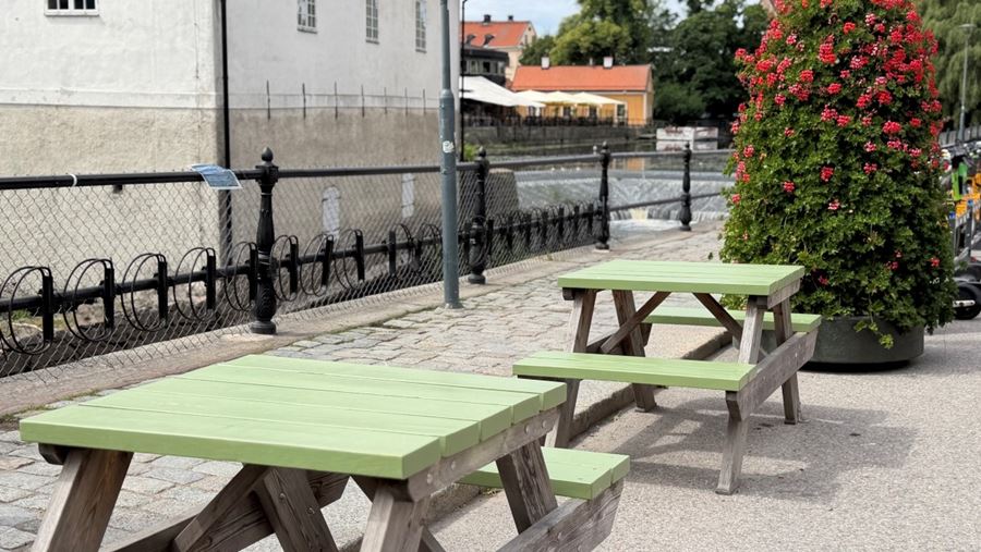 Bord och bänkar längs gatan vid ån