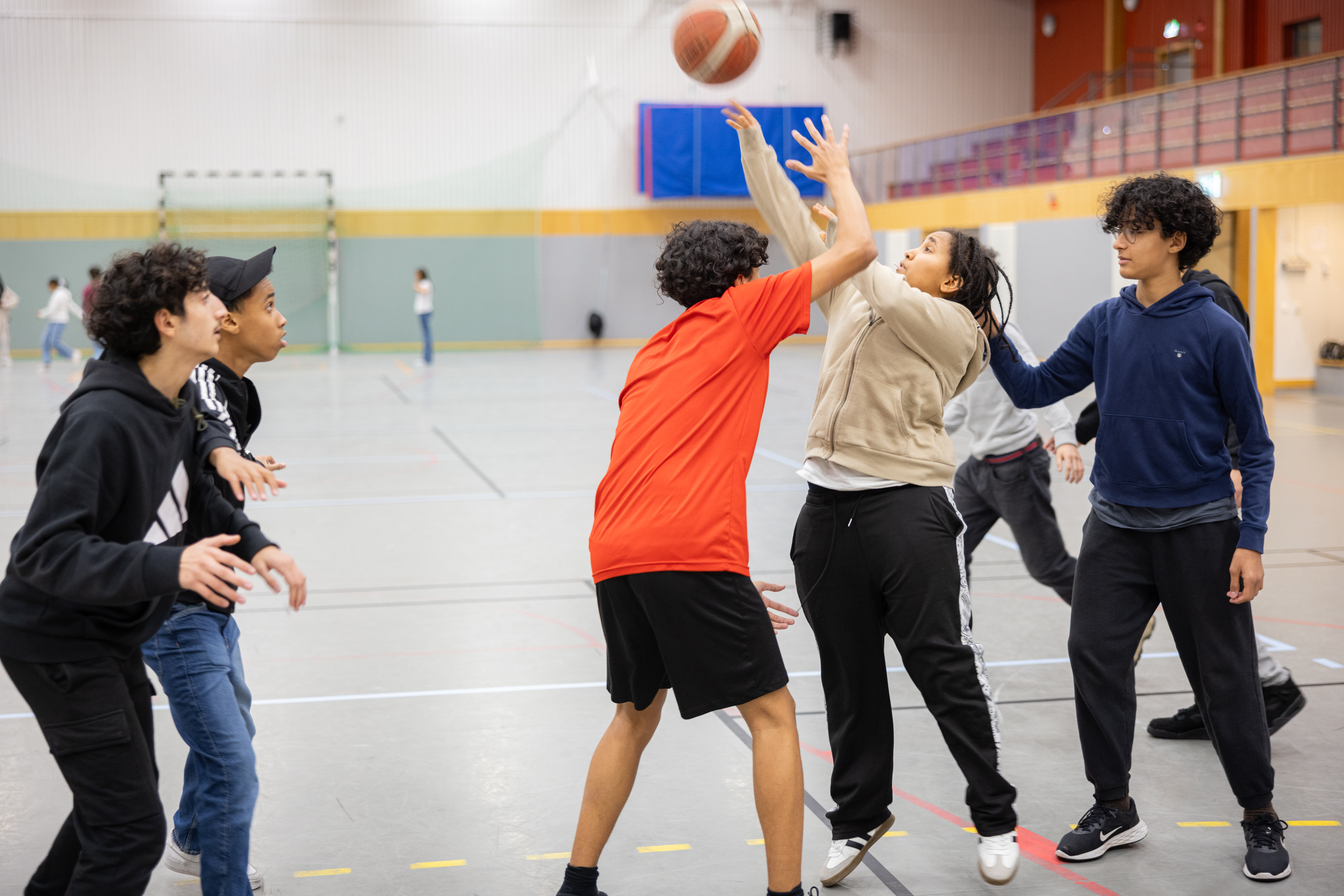 Ungdomar spelar basket.