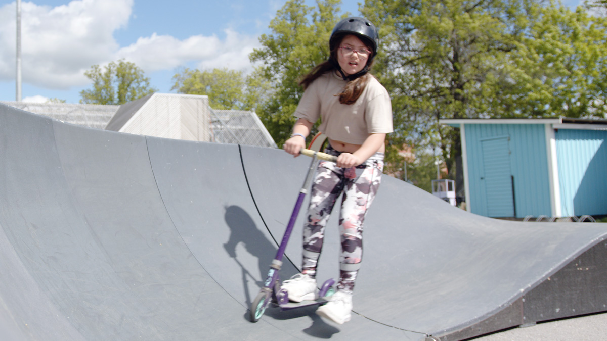 Tjej kör kickbike på ramp.