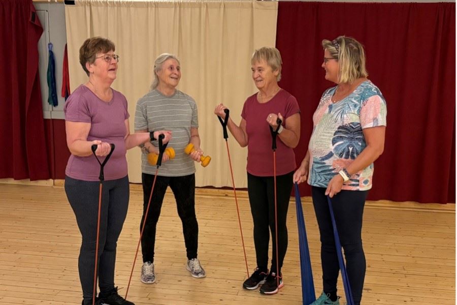 Kvinnor som står i grupp och styrketränar