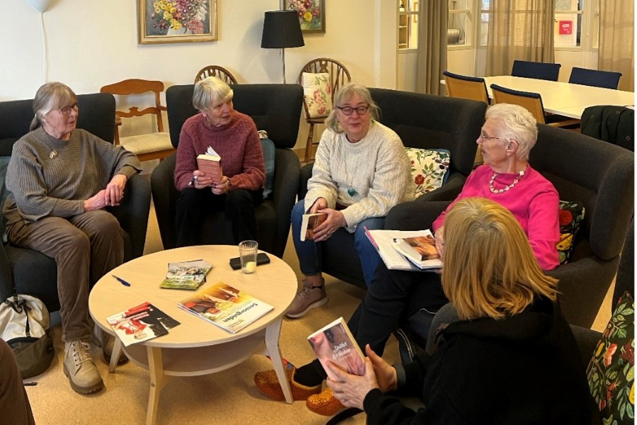 Personer som sitter i en bokcirkel och samtalar med varandra.