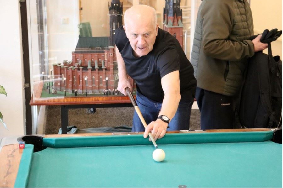 En person lutar sig fram över ett biljardbord och förbereder ett stötslag.