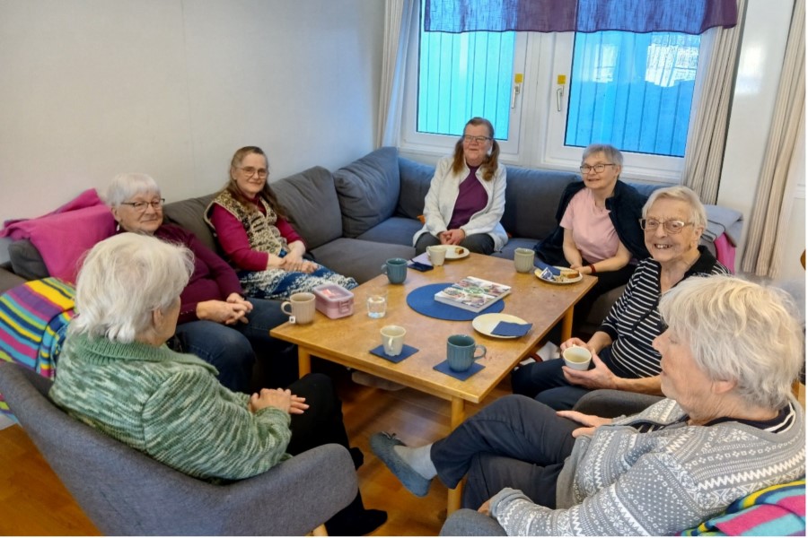 Människor sitter i en soffgrupp och samtalar.