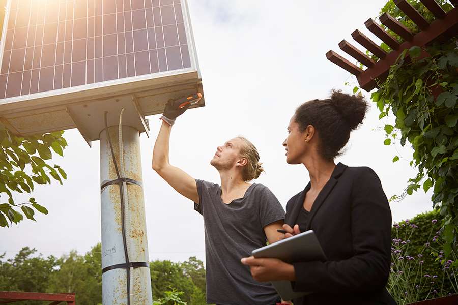 Man och kvinna inspekterar solceller