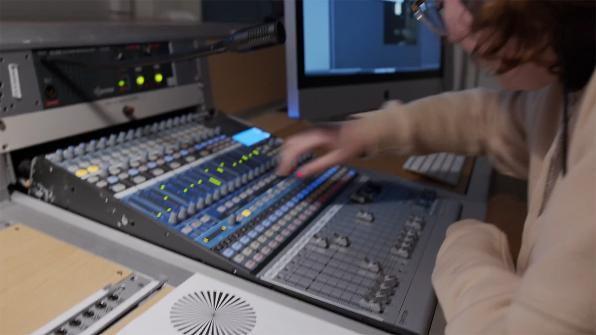 Hand som rattar vid ett mixerbord