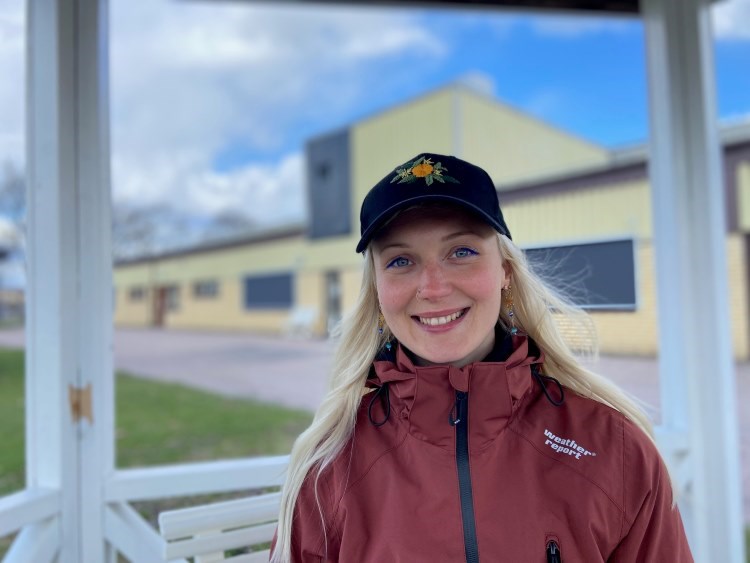 Porträttbild på Luna utomhus i keps och jacka.