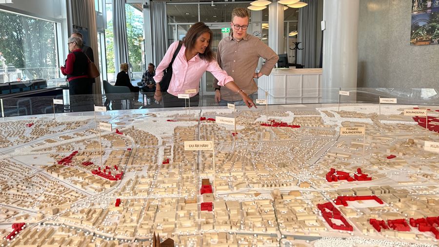 Två personer tittar på en stor stadsmodell som finns i Uppsalarummet.